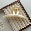 Detail van een 13 cm grote Franse vintage ivoren haarklem op een houten sieradentray - Rechte Stijl / Geel