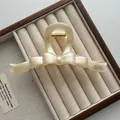 Detailweergave van een 13 cm grote crème vintage haarklem in een doosje - Vlinderdas Stijl / Geel