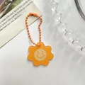 Levendige oranje acryl sleutelhanger in bloemvorm met een schattig smiley-ontwerp - Zon