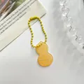 Leuke gele acryl sleutelhanger in de vorm van een pinda met bijpassende gele balketting - Pinda