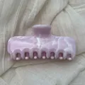 Detailed view of pink marble pattern on a French style hair claw clip with glossy finish - L / Pink