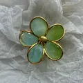 Vista detallada de la pinza para el pelo con forma de flor, pétalos verde degradado y borde dorado. - Flor Verde Lima con Borde Dorado