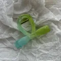 Vista macro detallada de una pinza para el cabello de gelatina verde sobre papel blanco - Verde Lima Pajarita