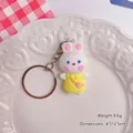 Adorable white bunny keychain wearing a yellow dress, displayed on a heart-patterned plate. - Rabbit / Yellow