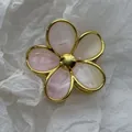 Detail shot of an elegant gold-framed marbled resin flower hair claw clip on white background - Smudged Gold Edge Flower