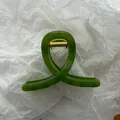 Close-up view of a translucent jelly green hair claw clip featuring golden metal spring - Jelly Dark Green