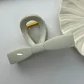 Detailed close-up view of a minimalist light grey bow-shaped large plastic hair claw clip - Bowtie Style / 11cm / Cyan Wood