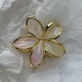 Macro view of a small marbled frangipani hair claw clip with elegant golden metal edges. - Smudged Gold Edge Frangipani