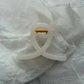 Detailed macro view of an elegant cream white jelly hair claw clip with durable gold spring - Jelly White