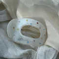 Detailed macro view of cream white acetate hair claw clip decorated with colorful rhinestones - Lazy Duck Clip