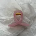 Close-up of a jelly pink cross-shaped hair claw clip on white wrinkled paper background. - Jelly Pink