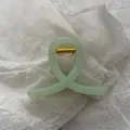 Detailed view of a mint green jelly hair claw clip with an elegant cross-loop design - Jelly Green