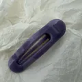 Detailansicht einer großen violetten Jelly-Haarklammer mit elegantem geschwungenem Design. - Lila