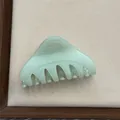Close-up detail of a minimalist light green triangular hair claw clip with a sleek finish - Fruit Green