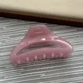 Detailed view of a minimalist pink hair claw clip with a glossy finish. - Fruit Pink
