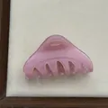 Detail view of a translucent pink triangular hair claw clip for elegant hairstyles - Fruit Pink