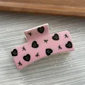 Close-up detail of a pink macaron square hair claw clip featuring heart and bow print designs. - Cube Shape / L / Pink
