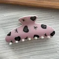 Close-up detail of a pink hair claw clip featuring black heart and bow UV patterns - Ingot Shape / L / Pink