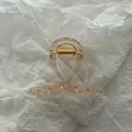 Detailed close-up of translucent champagne jelly hair claw clip on white textured paper - Champagne