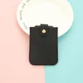 Sleek black PU leather card holder with secure gold-tone snap button closure. - Black