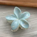 Close-up detail of a sweet light blue flower shaped hair claw clip with white bow patterns - Flower / M / Blue