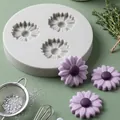 Close-up detail of 3-cavity daisy silicone mold alongside finished purple floral crafts - Gray