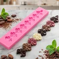 Vue détaillée du moule en silicone fleur de cerisier 3D avec chocolats sur marbre - Rose