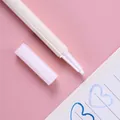 Detalle de un rotulador metálico blanco con punta fina azul sobre fondo rosa - Blanco