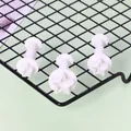 Detailansicht von 3 weißen sternförmigen Fondant-Ausstechern mit Federkolben auf Gitter. - Sternform (01090)