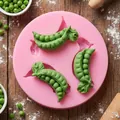 Dettaglio dello stampo in silicone a baccello di pisello con fondente verde su legno - Rosa