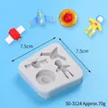 Detailed view of square silicone mold showing space-themed shapes and finished decorations - Astronaut 4-in-1 White Mold (50-3124-B) / 50-3124-B / White