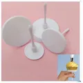 Primer plano de cuatro clavos de flores de plástico blanco para decorar pasteles DIY - Set de 4 piezas