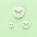 Set van drie witte vlindervormige fondant uitstekers op een lichtgroene achtergrond - Vlindervorm (3-delige Set) / 04020