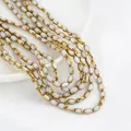 Nahaufnahme weißer ovaler Kristallglasperlen mit elegantem Goldrand für DIY-Schmuckherstellung. - 1 Strang (Ca. 50 Stk/32cm) / Gebrochenes Weiß