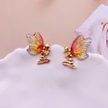 Dettaglio di orecchini a forma di fata dorata con ali di farfalla colorate - Arancio Oro