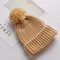 Warme beige gebreide kindermuts voorzien van een grote zachte decoratieve pompon - Khaki