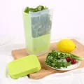 Détail d'une boîte de conservation verte transparente pour légumes sur une planche - Vert