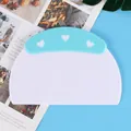 Close-up view of a light blue plastic dough scraper featuring a heart pattern and scale. - Boxed Scale Style (84069)