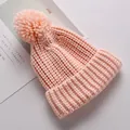 Gezellige roze gebreide kindermuts met een zachte pompon en geribbelde omslagrand - Roze