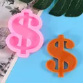Detailed view of a pink dollar sign silicone mold next to an orange resin casting for DIY crafts - Dollar Sign Style (50-2264-A) / Pink