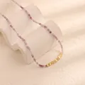 Dettaglio macro di una collana di perle naturali viola con inserti dorati lucidi - Fluorite Pezzi d'Oro