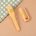 Mini spazzola per capelli pieghevole gialla con simpatico volto cartoon - Giallo