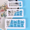 Detail view of three white plastic jigsaw puzzle shaped geometric baking cookie cutters - Puzzle Style (72107) / Three-Piece Set