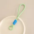 Minimalistisches geflochtenes Handyband mit blauem Knotendetail in attraktivem Hellgrün - Grün