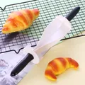 Detail view of a plastic croissant roller cutter with spiral blades on a cooling rack - Spiral Roller Cutter / Black and White Patchwork