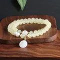 Detailansicht eines Perlenarmbands im neuen chinesischen Stil mit einem weißen Anhänger. - Light Yellow (Topaz)