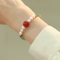 Detail of beaded bracelet with green aventurine, white pearls and red agate on wrist - Pearl Bracelet
