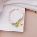 Close-up detail of beaded bracelet with white pearls, jade beads and lucky gold charm - No. 4 Auspicious