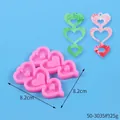 Pink heart-shaped earring silicone mold with finished resin pendants on blue background - Triple Heart Tassel Style (50-3035-A)