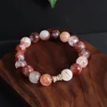 Detailansicht eines 12 mm großen roten Quarzperlenarmbands mit goldenem Zirkon-Abstandshalter. - Taillenförmiger Perlenstil / 12mm